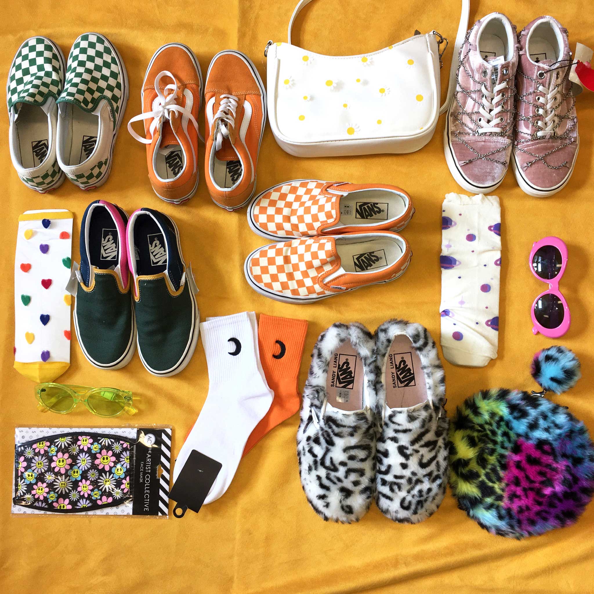 A few pairs of Van's shoes, socks, fun sunglasses and other accessories over a yellow background