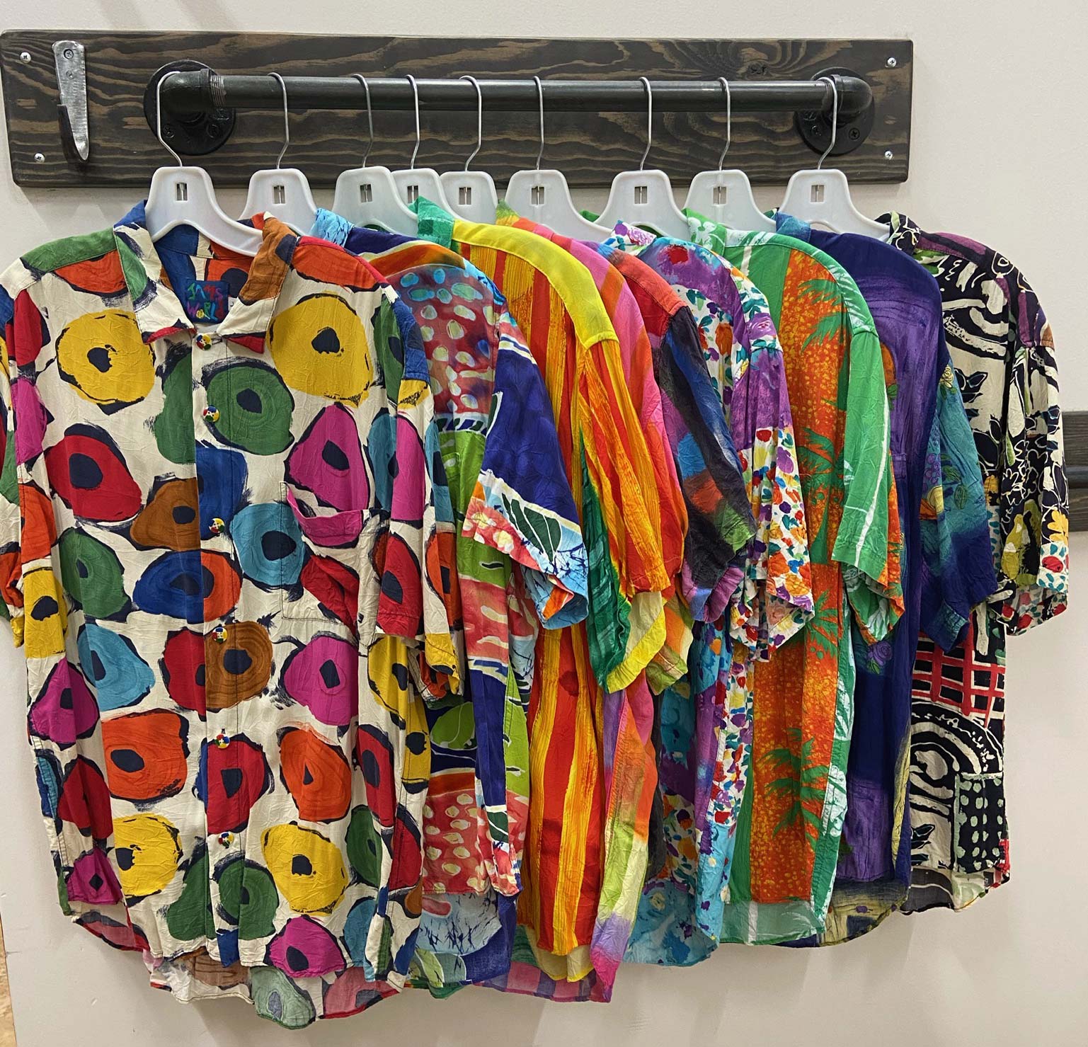 Colorful Jams World shirts hanging on rack Andersonville