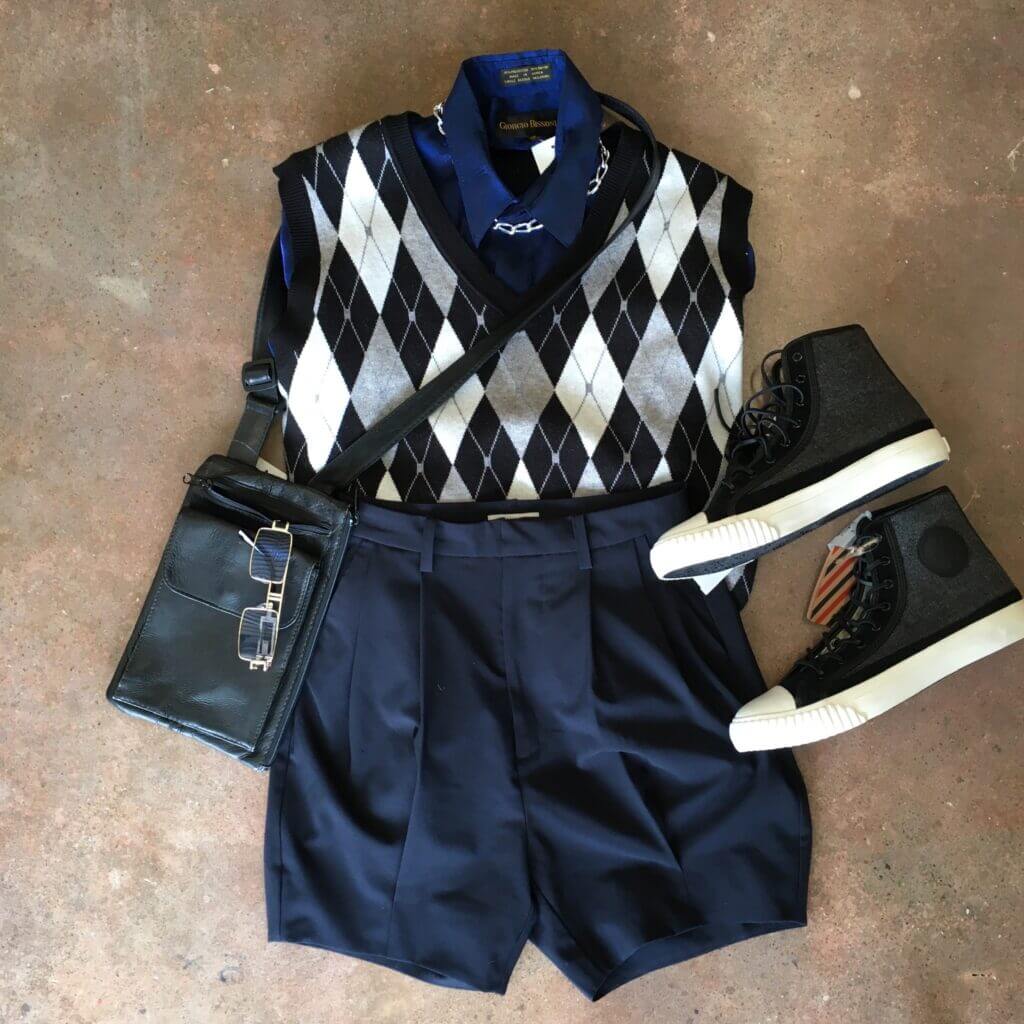 Argyle sweater vest styled with navy blue shorts and black sneakers