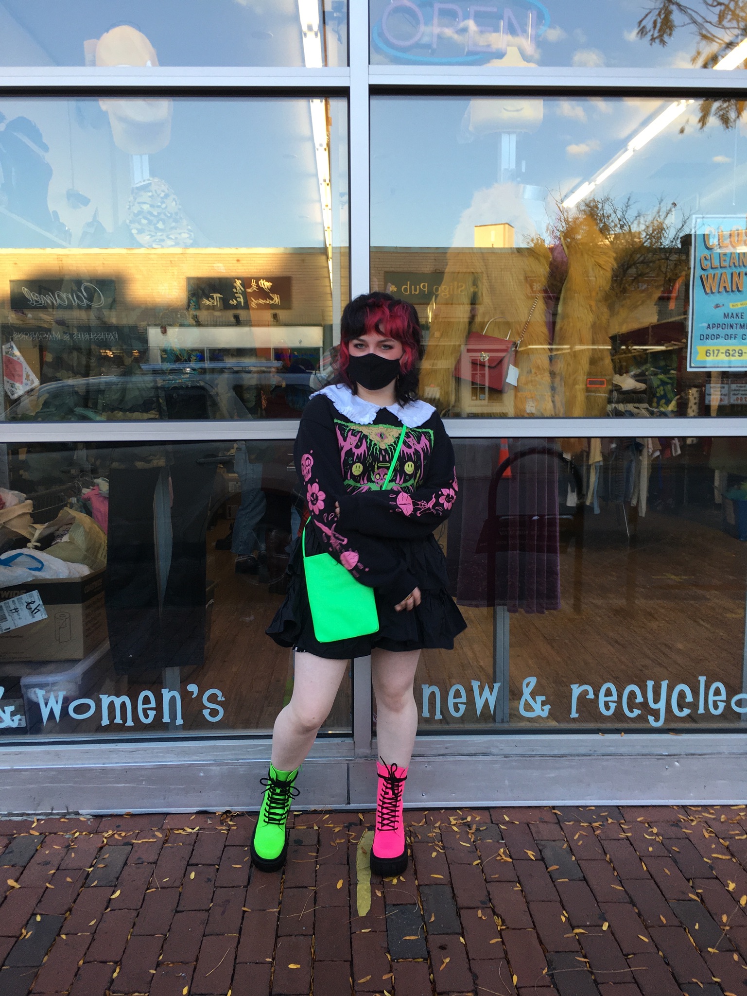 Person wearing granny collar, graphic sweater, mini skirt and neon accessories