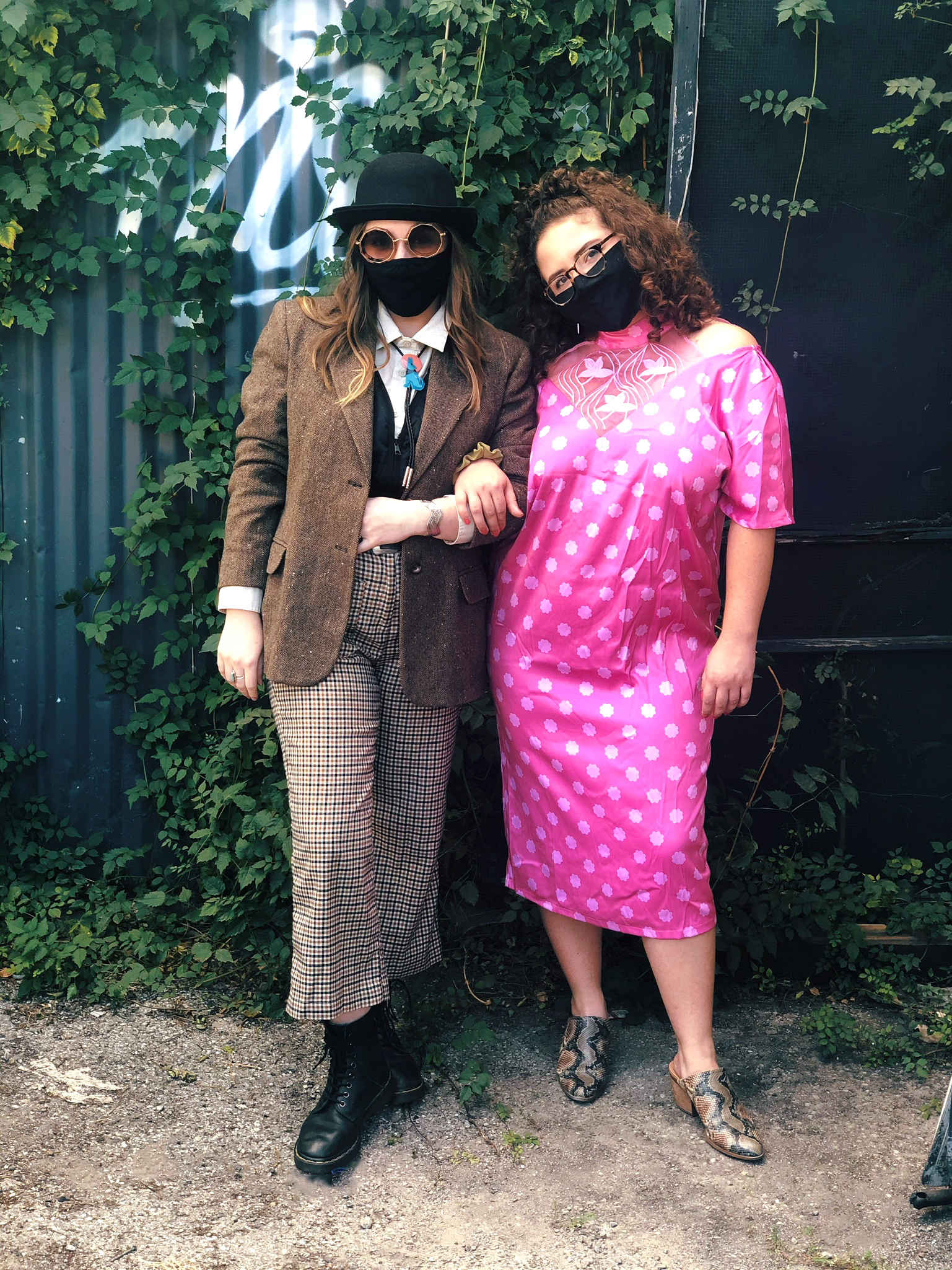 2 People Dressed up as Pretty in Pink for Halloween, one wearing brown checker pants, brown blazer and bowler hat, one in pink polka dot dress