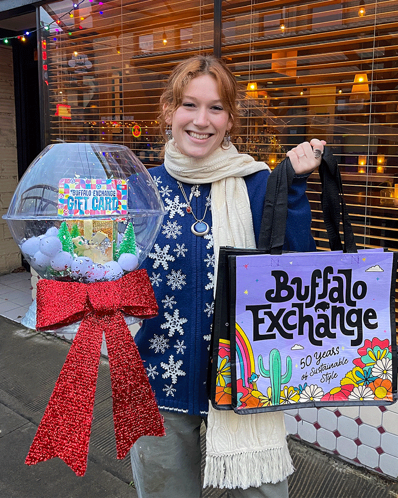 woman holding oversized snow globe and Buffalo Exchange reusable tote bags