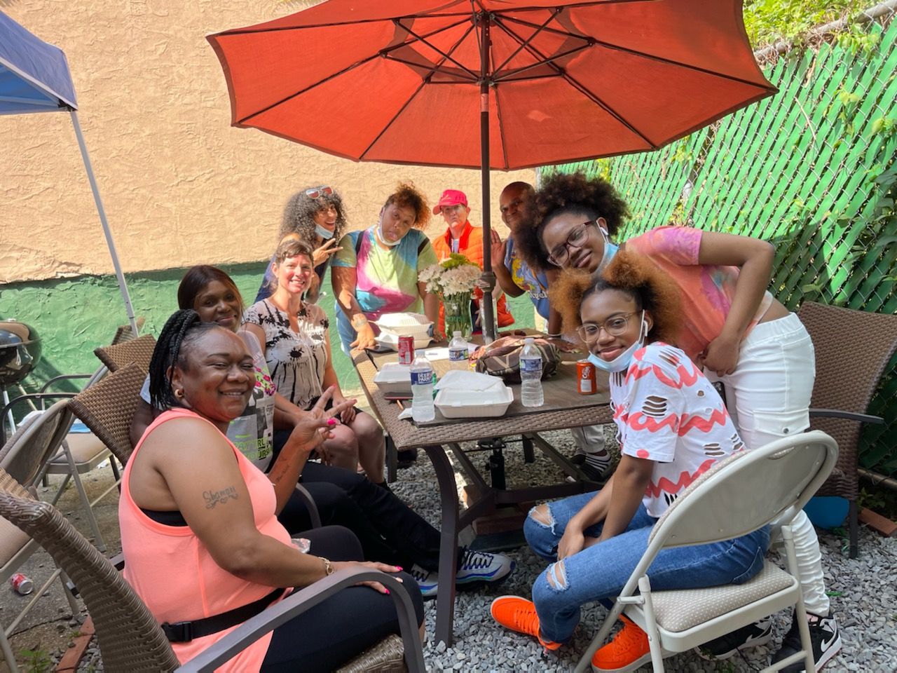 A group of 9 people sitting at a table posing and having a good time