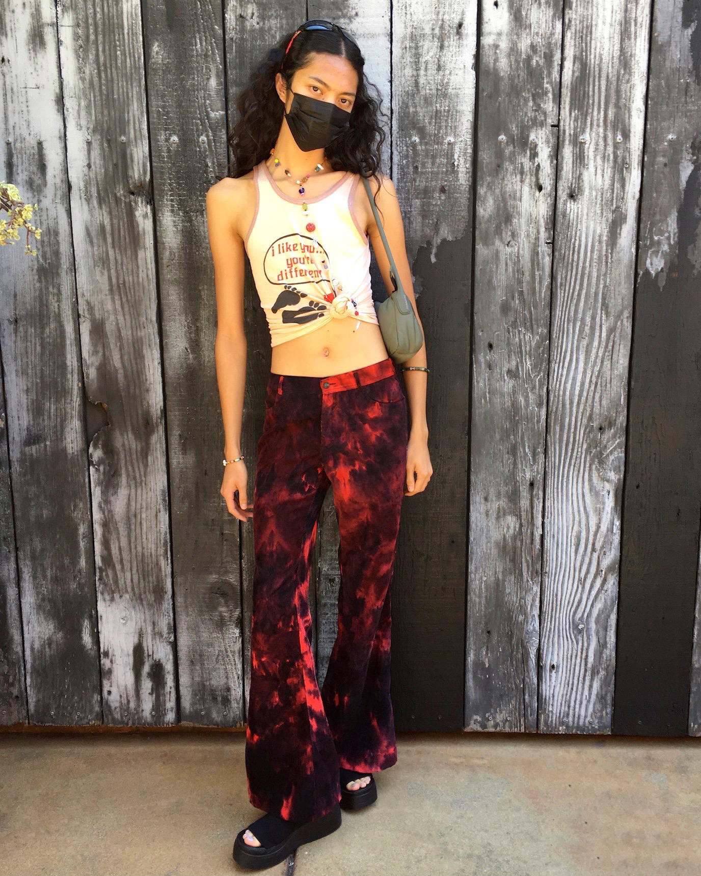 Girl Posing wearing red low-rise pants and a graphic tank top