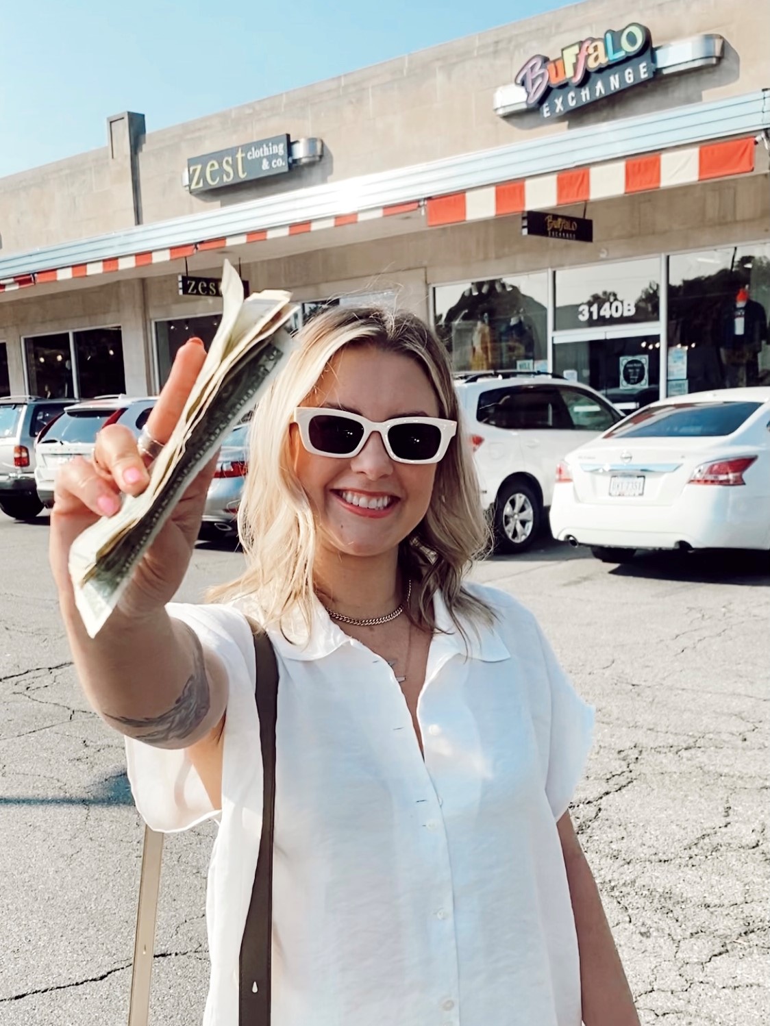 Woman in white top with cash in hand