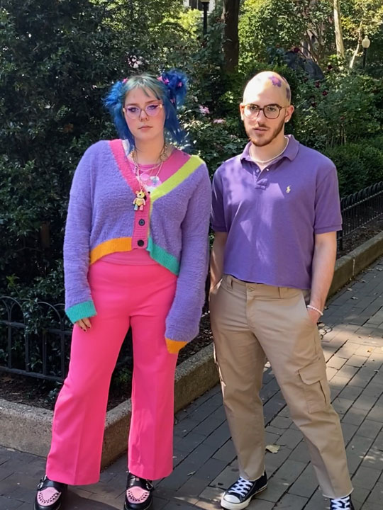 A man and a woman posing at a park wearing colorful clothing