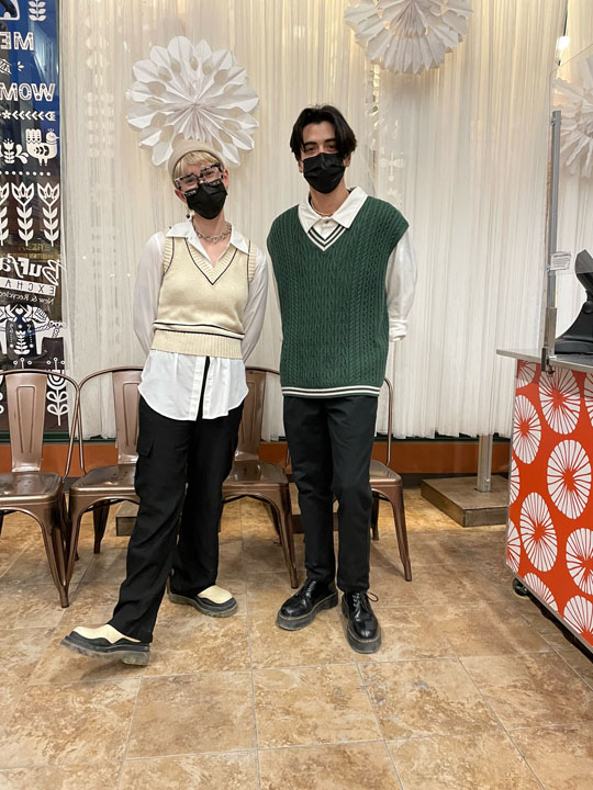 two people wearing white collared shirts and sweater vests