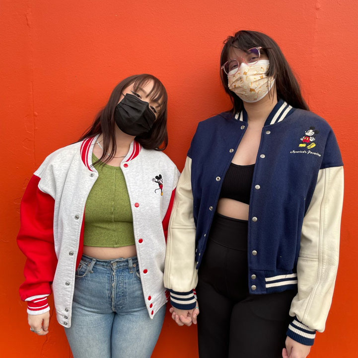 Two women wearing varsity jackets