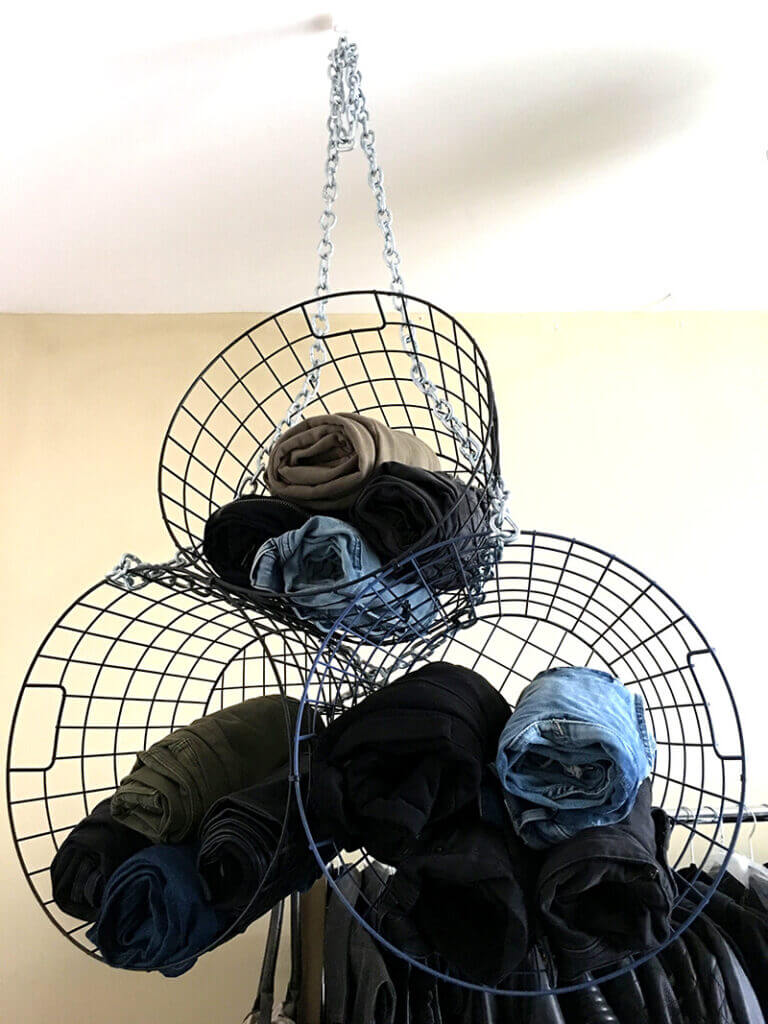 3 metal baskets stacked on top of each other with clothes inside