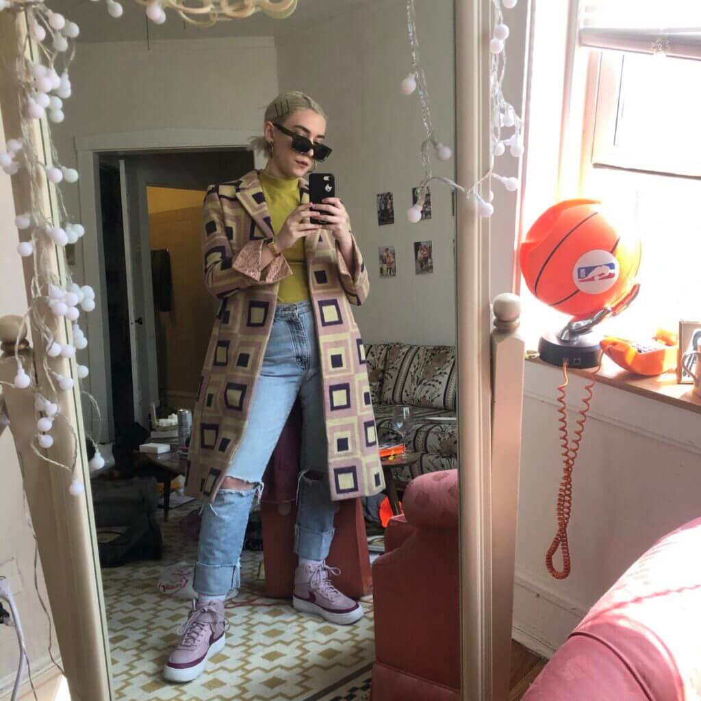 Person taking picture of themself in the mirror with a phone