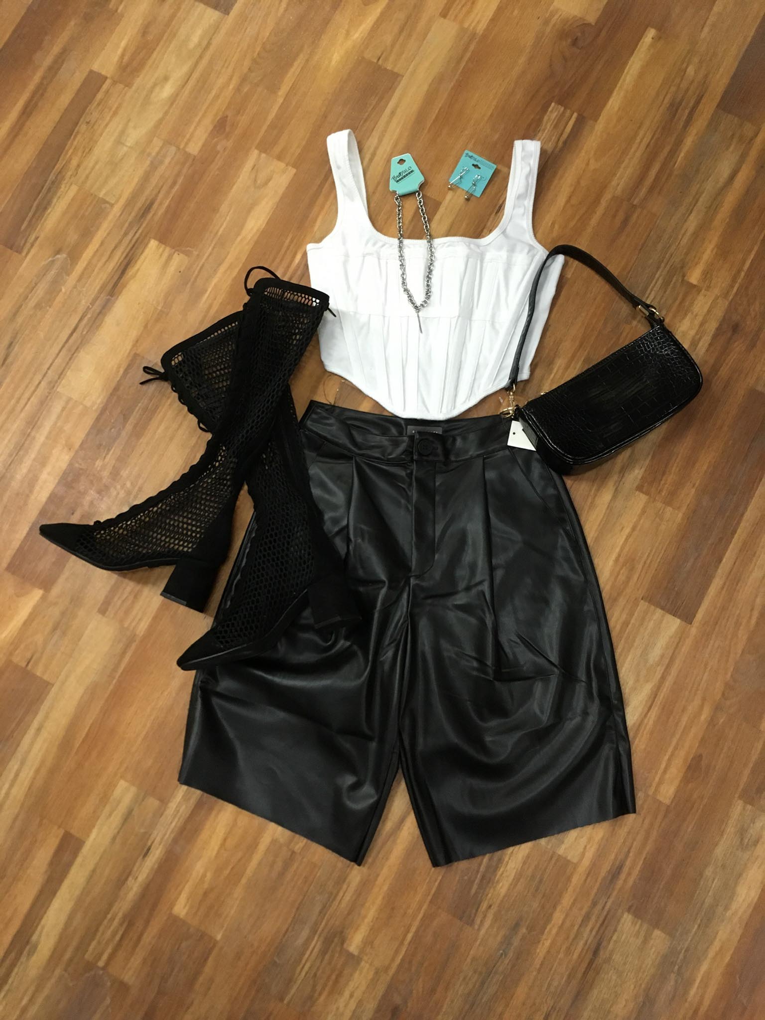 white corset tank top, vegan leather culotte shorts, black lace-up calf boots and small black baguette bag