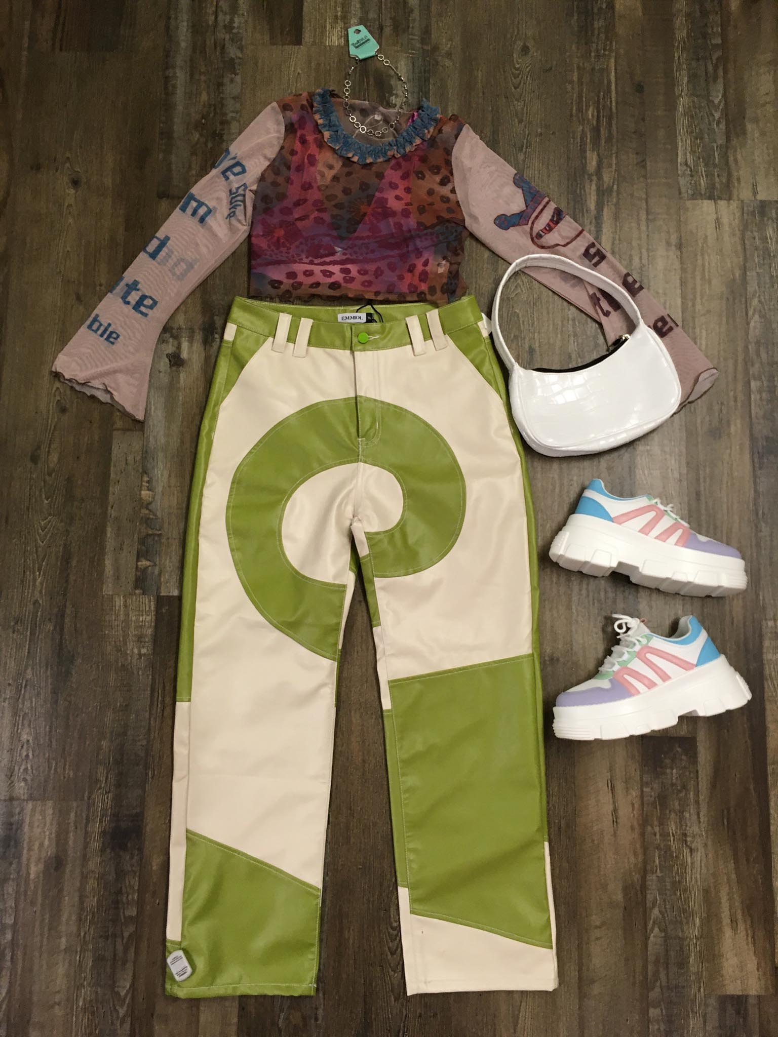 green and beige swirl-patterned pants styled with mesh top and platform sneakers