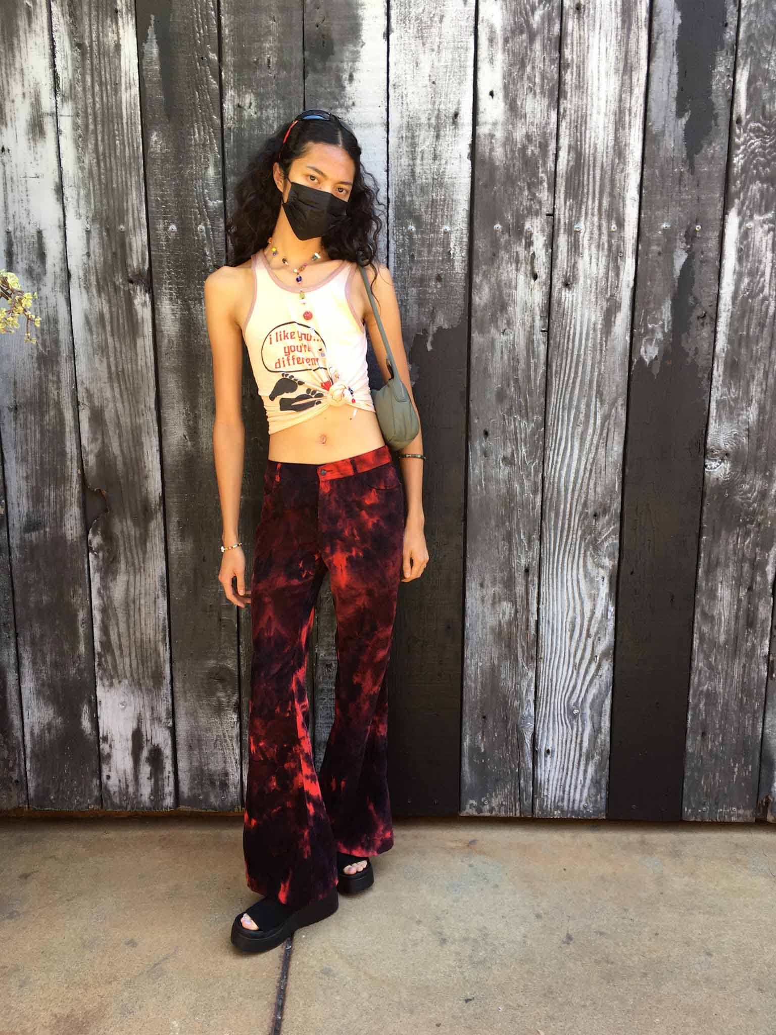 Girl Posing wearing red low-rise pants and a graphic tank top