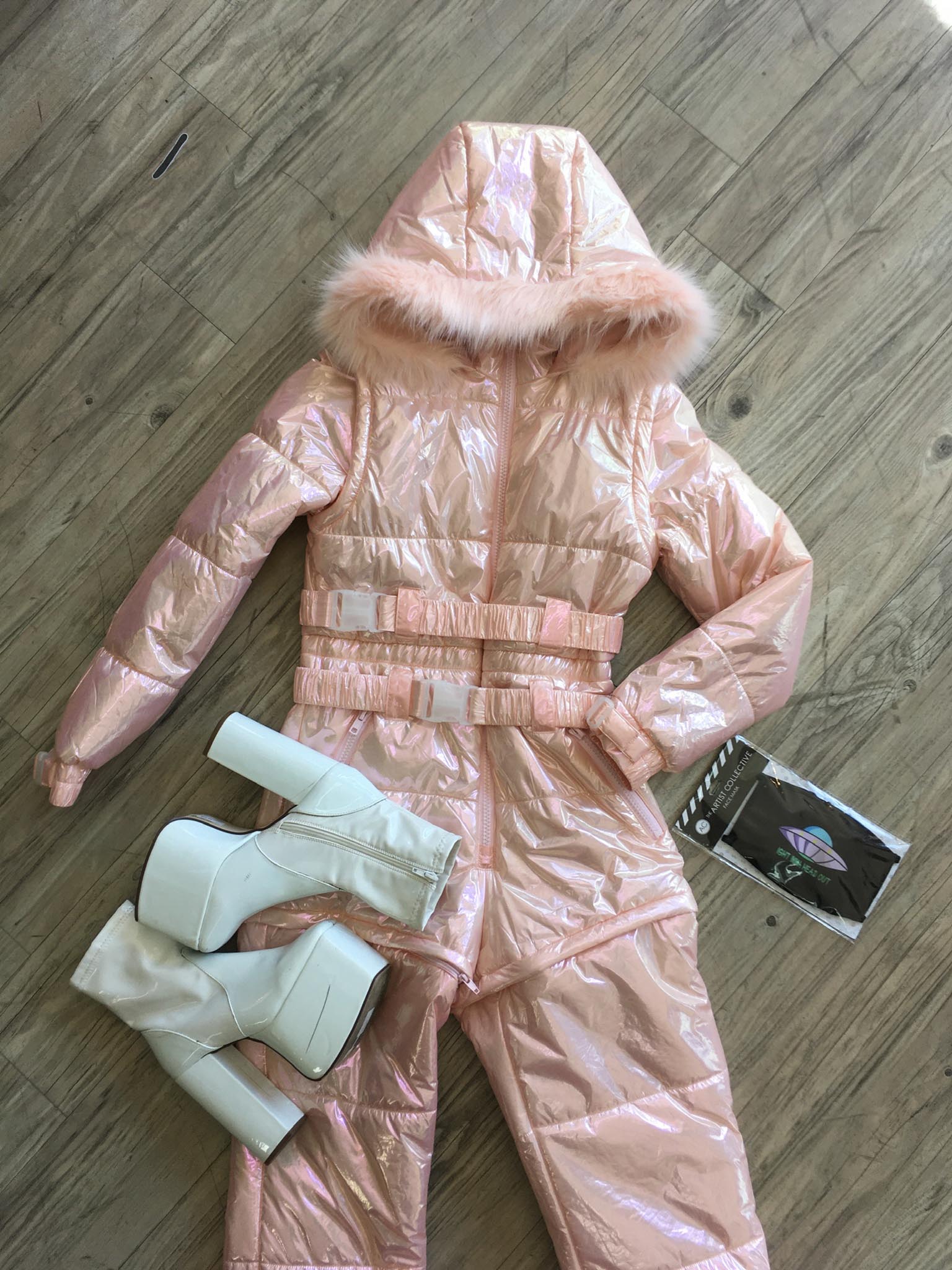 Aerial view of pearlescent pink snowsuit and white platform boots