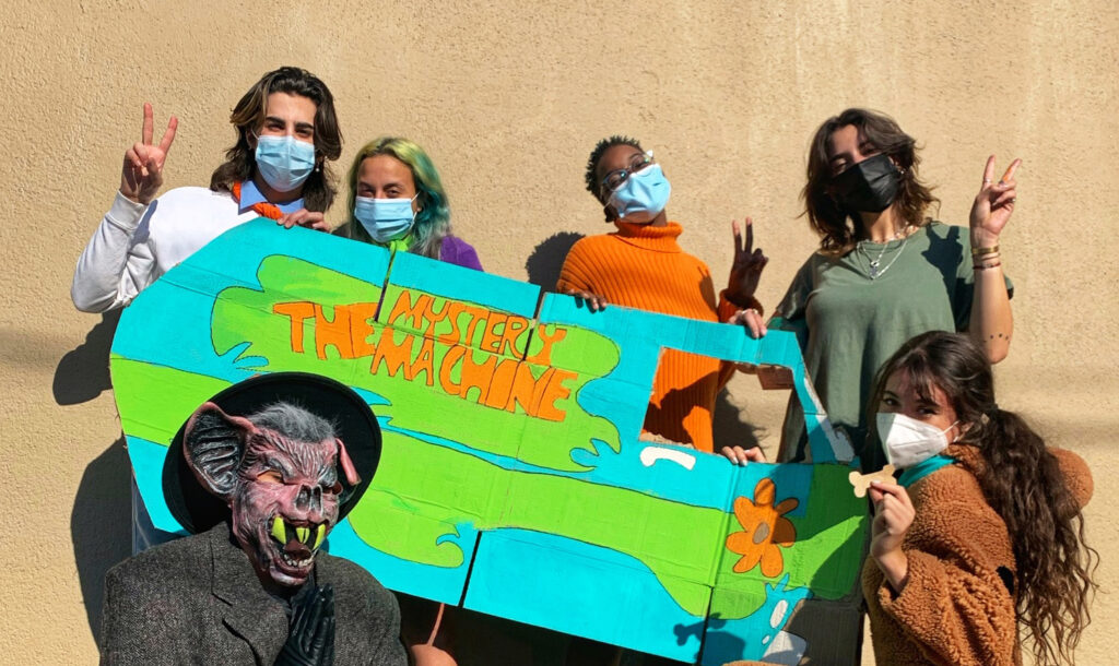 Group of people in costume as the characters from Scooby Doo posing with a handcrafted cardboard Scooby Doo van