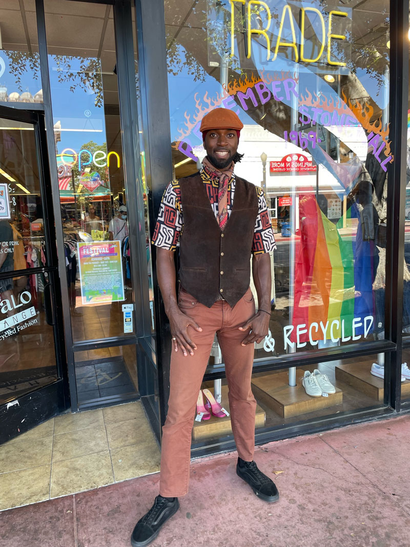 Person wearing brown suede vest over printed button-down and clay-colored pants