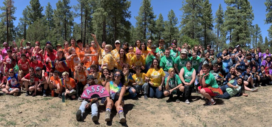 Large group of people wearing a rainbow of colored t-shirts