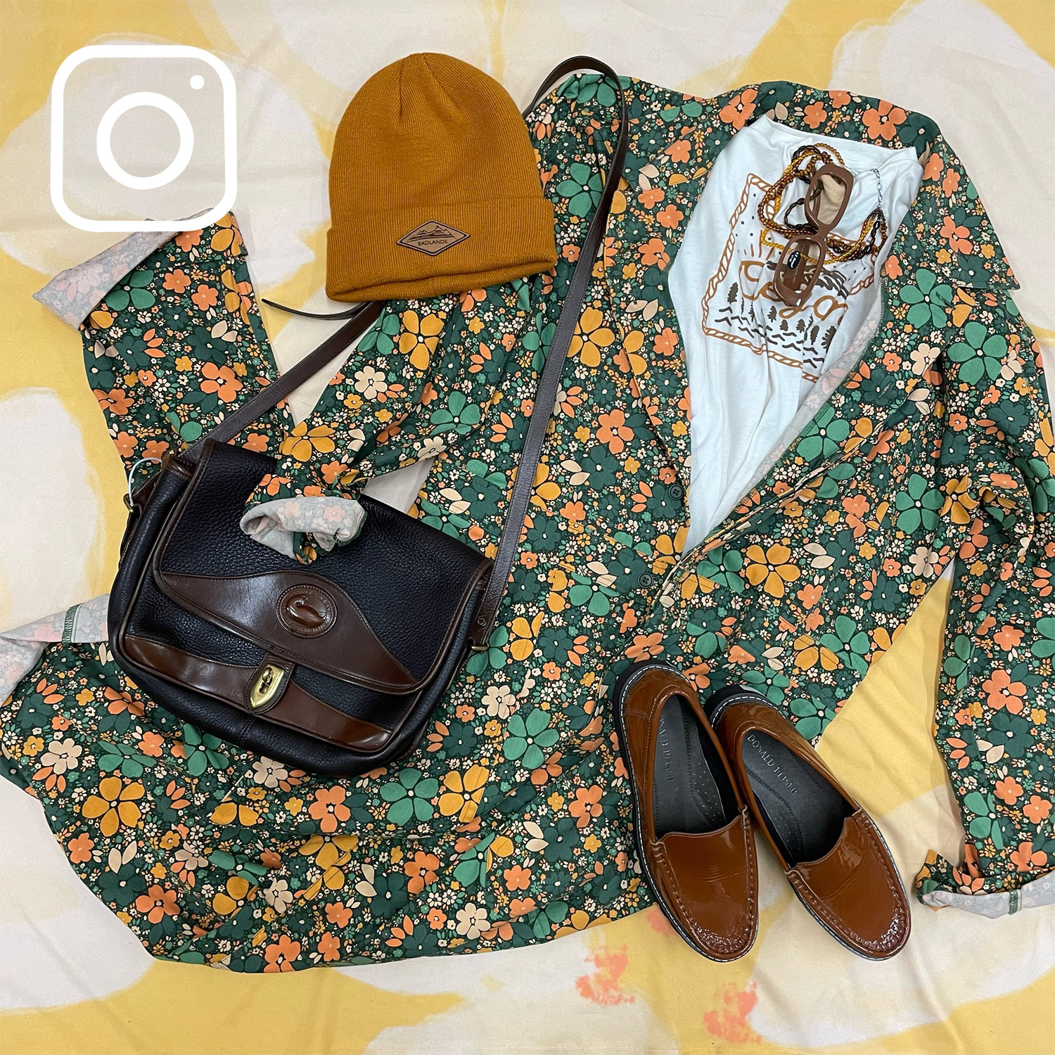 Flatlay of a floral outfit paired with a beanie hat, specs, purse, and leather shoes. [Instagram logo]