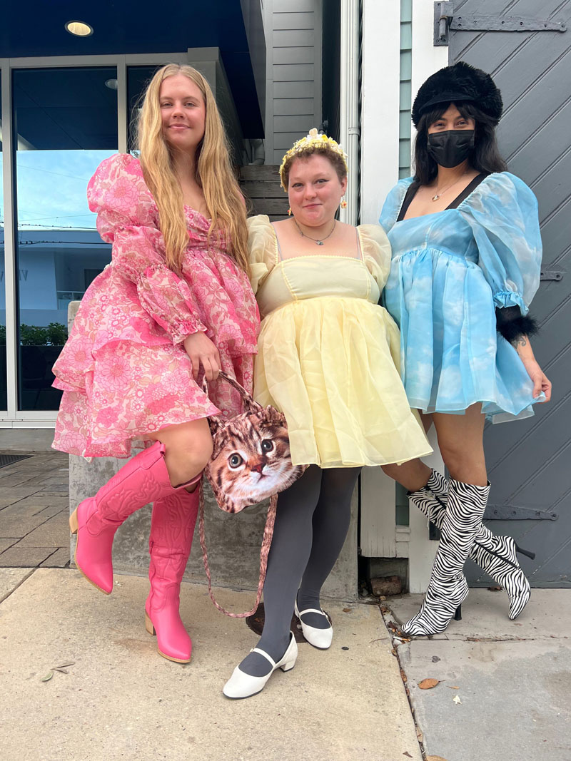 three people stand on a sidewalk wearing voluminous, pastel Selkie dresses