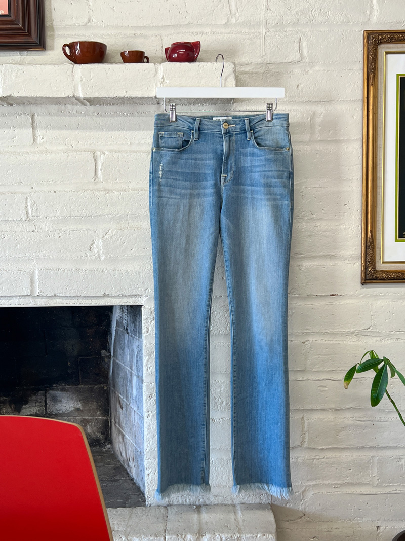 Light wash bootcut jeans with a raw hem from the brand FRAME