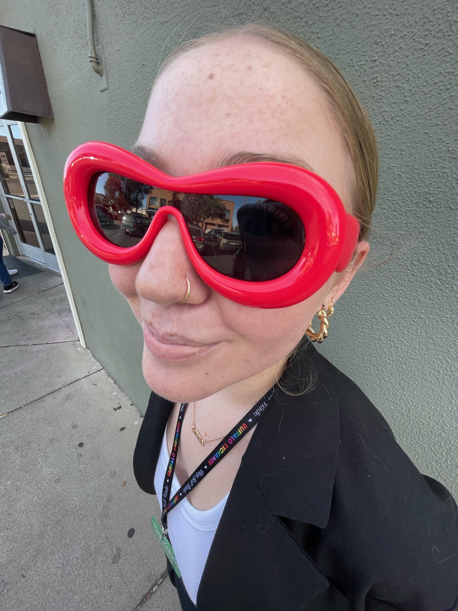 headshot of a person wearing round frame red sunglasses