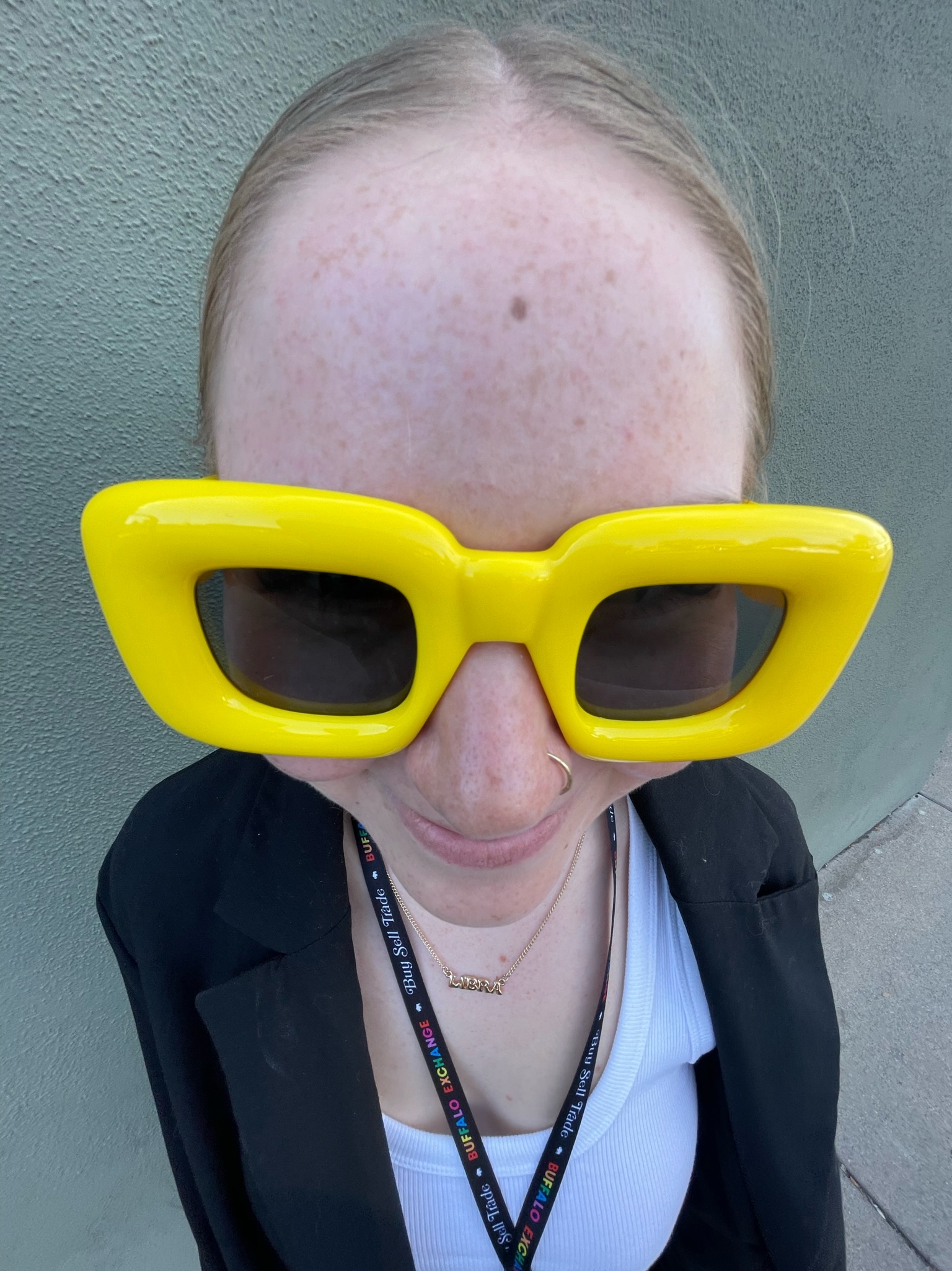 headshot of a person wearing square frame yellow sunglasses