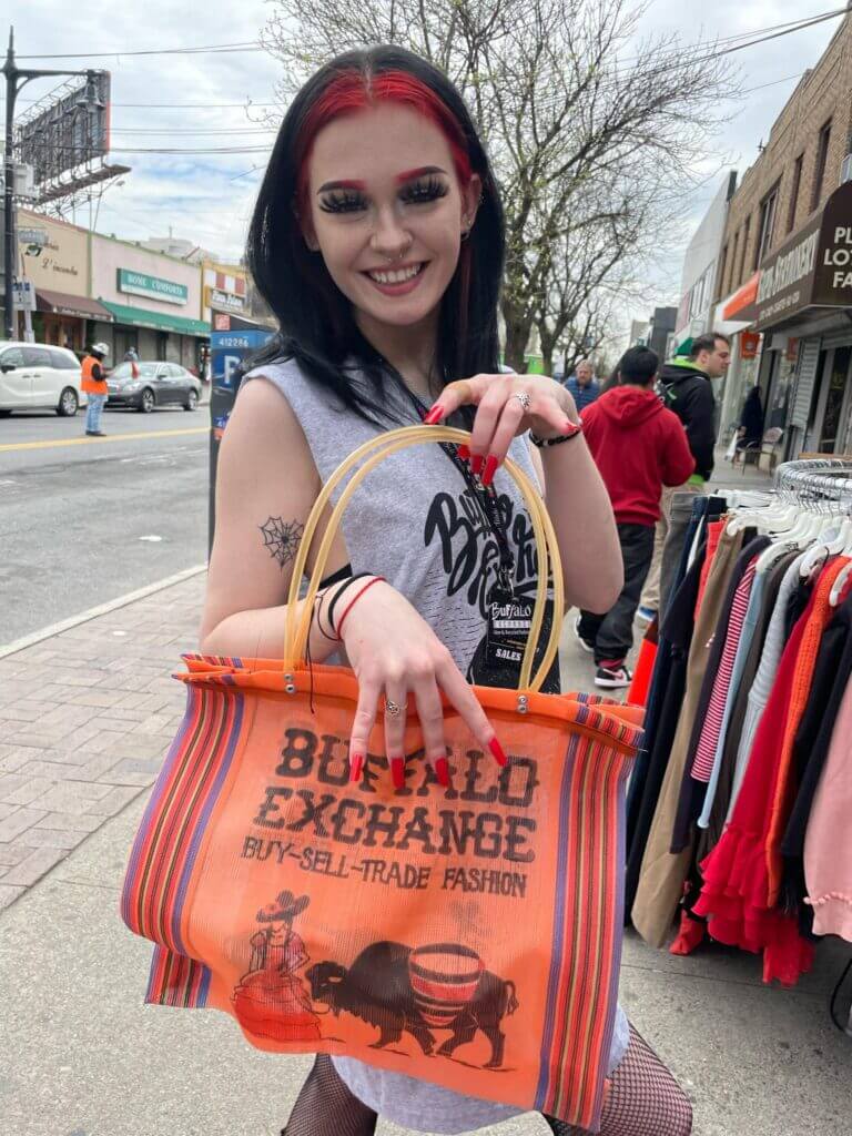 Buffalo Exchange employee holding a tote bag