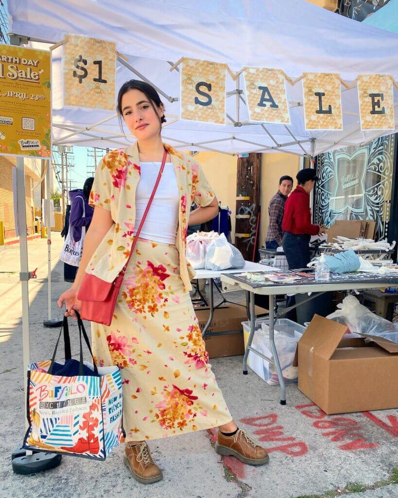 a person holding a Buffalo Exchange tote full of $1 items at the Earth day $1 Sale