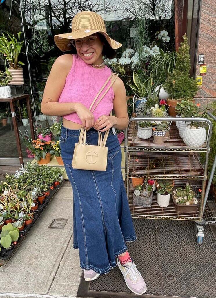 Person Wearing Jean Maxi Skirt, Pink Crop Top, Straw Hat and Mini Telfar