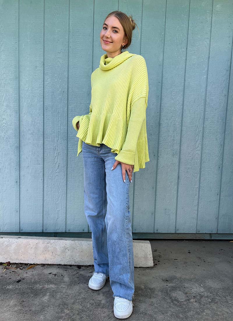 Person Wearing Lime Green Sweater & Jeans With White Sneakers