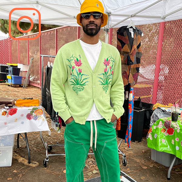 Person wearing floral green cardigan and yellow bucket hat