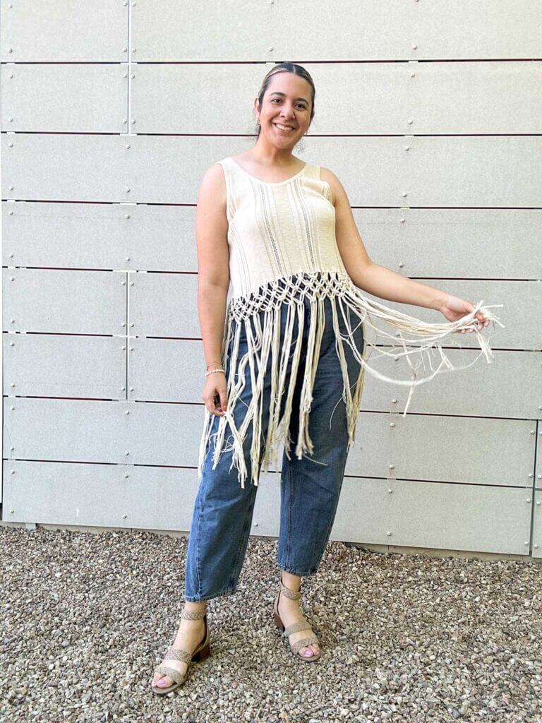 a woman wearing a crochet top with fringe