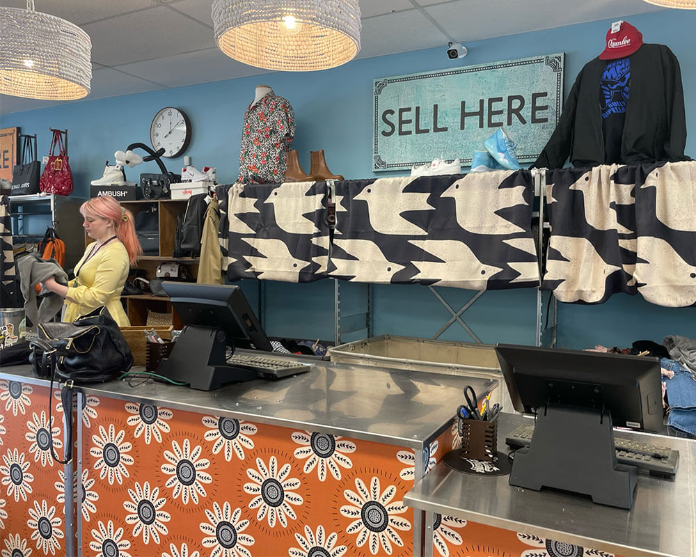 Buffalo Exchange Eugene buy counter with sign that reads "Sell Here"