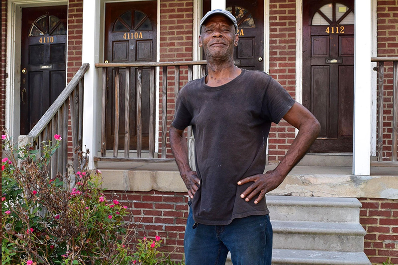 Person standing in front of brick house