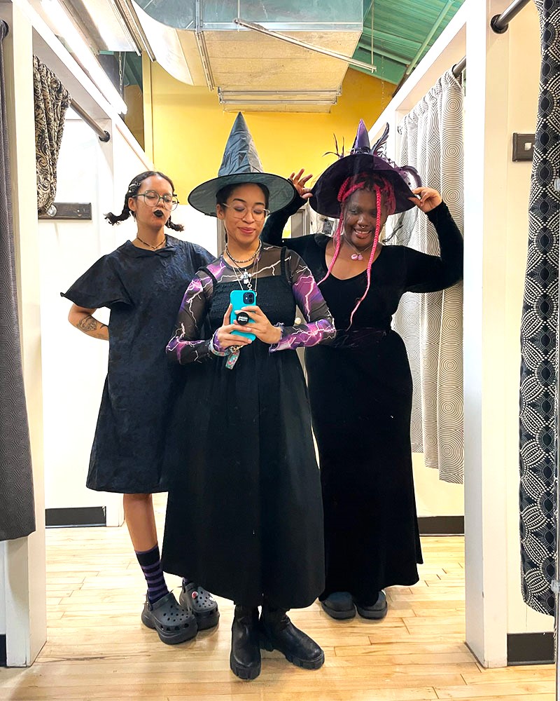 3 people pose for mirror selfie dressed in  classic black witch costumes