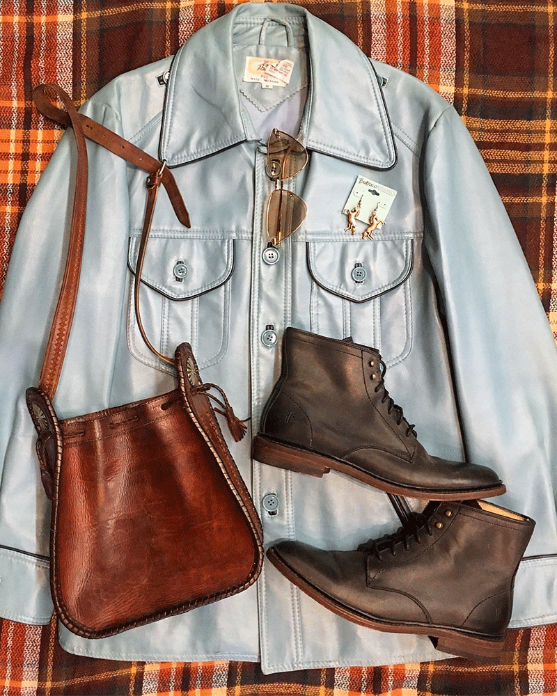 Flat Lay of blue leather jacket with brown satchel and boots