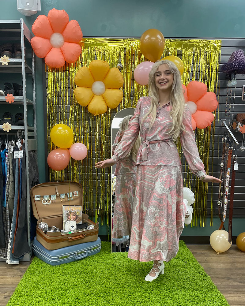 Person wearing vintage dress in front of groovy backdrop