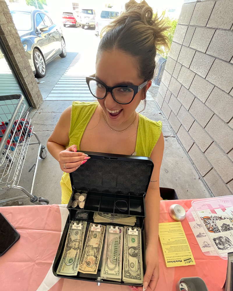 Employee showing money made from dollar sale