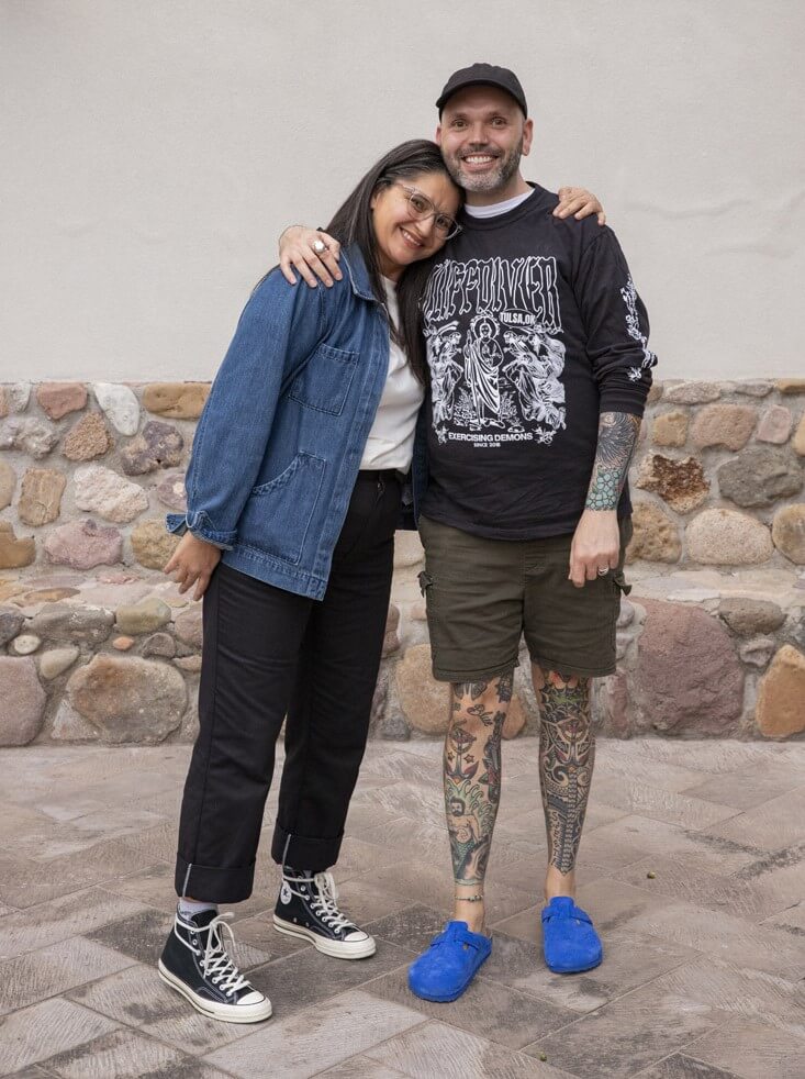 Mike and Mina smiling for the camera in front of rock wall
