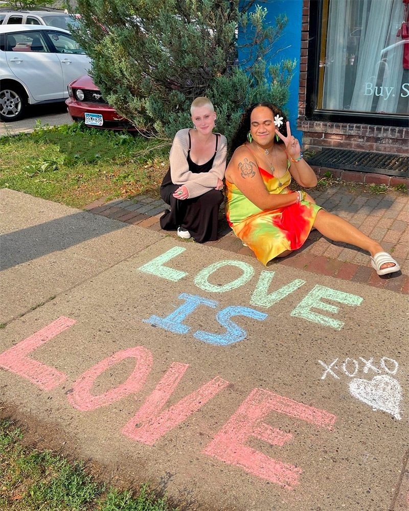 Two Buffalo employees showing off their pride sidewalk chalk