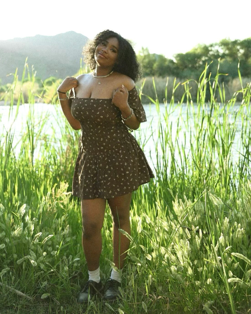 woman standing in a meadow near a lake