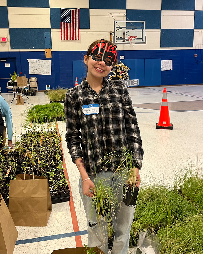 Thinklikeabee---Vertical Community member smiling and wearing ladybug mask while working with plants