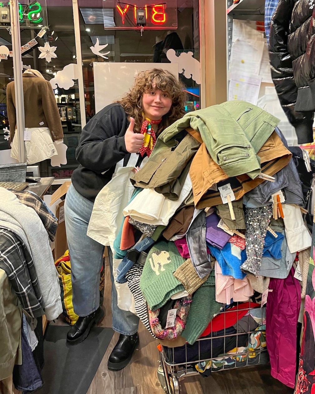 Buffalo Exchange employee standing next to a pile of clothes
