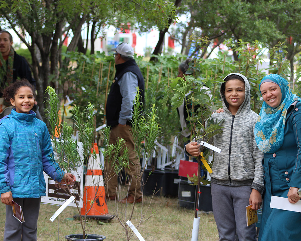 Children and volunteers with plants at a community event.