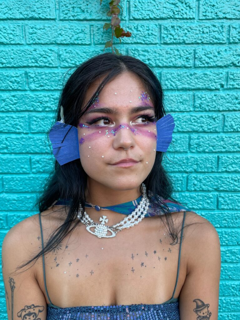 A close-up of a woman dressed as a fish for Halloween, with DIY gills and glittery makeup.